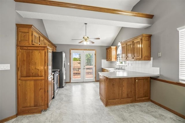 3605 NW Pier Ct, Blue Springs, MO 64015 - kitchen with vaulted ceiling, brown cabinetry, a peninsula, stainless steel appliances, and a ceiling fan