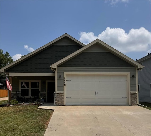 1141 S Main St, Ottawa, KS 66067 - craftsman-style home with stone siding, a garage, driveway, and covered porch