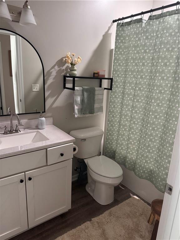 1141 S Main St, Ottawa, KS 66067 - full bath featuring wood finished floors, vanity, and shower / bath combo