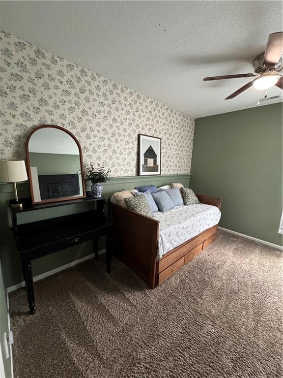 1141 S Main St, Ottawa, KS 66067 - bedroom with wallpapered walls, a textured ceiling, carpet floors, and ceiling fan