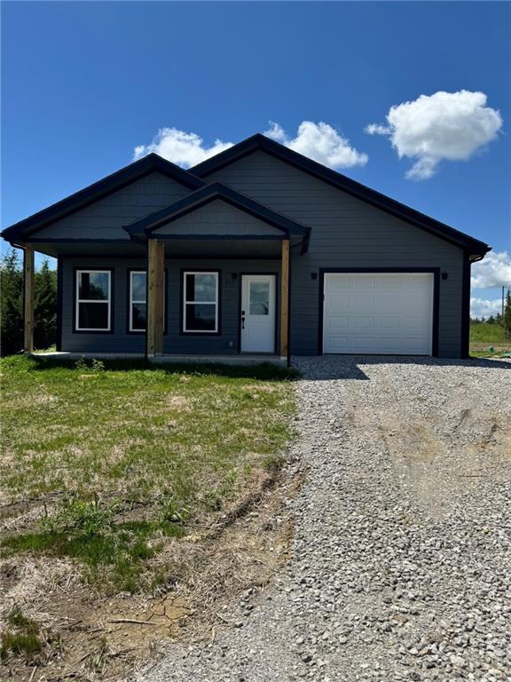 213 Bald Eagle Dr, La Cygne, KS 66040 - view of front facade with gravel driveway and a garage