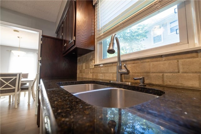 1604 SW 21st St, Blue Springs, MO 64015 - kitchen featuring healthy amount of natural light, dark brown cabinetry, dark stone countertops, and decorative backsplash