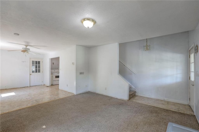 934 Williams St, Excelsior Springs, MO 64024 - unfurnished living room featuring stairs, carpet, and a ceiling fan