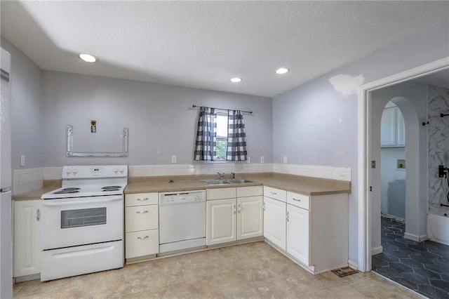 934 Williams St, Excelsior Springs, MO 64024 - kitchen with white appliances, arched walkways, a textured ceiling, recessed lighting, and light countertops