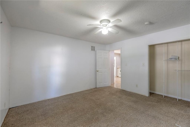 934 Williams St, Excelsior Springs, MO 64024 - unfurnished bedroom featuring carpet, a closet, ceiling fan, and a textured ceiling