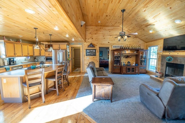 28909 E 297th St, Garden City, MO 64747 - living room with wood ceiling, wooden walls, light wood-type flooring, a ceiling fan, and lofted ceiling