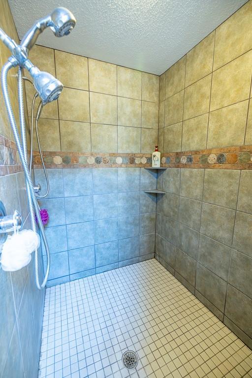 28909 E 297th St, Garden City, MO 64747 - bathroom with a tile shower and a textured ceiling