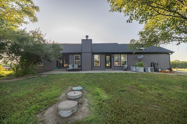 28909 E 297th St, Garden City, MO 64747 - rear view of house featuring a patio area, a lawn, and a chimney