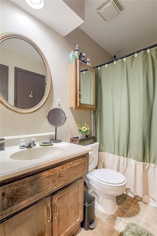 9514 W 77th Ter, Overland Park, KS 66204 - full bath with vanity, a shower with curtain, and tile patterned floors