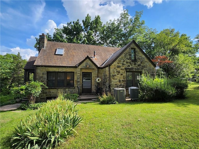 315 N 1st St, Independence, KS 67301 - tudor home with a front lawn, stone siding, and a chimney