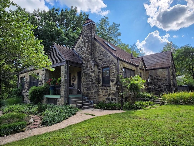 315 N 1st St, Independence, KS 67301 - view of front facade featuring stone siding, a front lawn, and a chimney