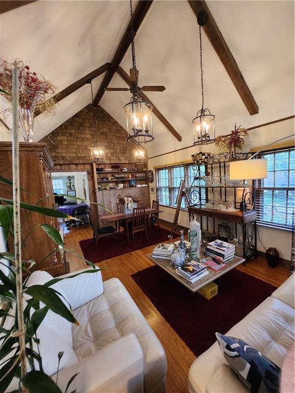 315 N 1st St, Independence, KS 67301 - living area with a chandelier, beam ceiling, wood finished floors, a ceiling fan, and high vaulted ceiling