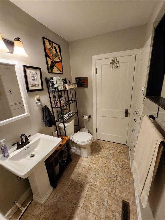 315 N 1st St, Independence, KS 67301 - bathroom featuring stone tile flooring and toilet
