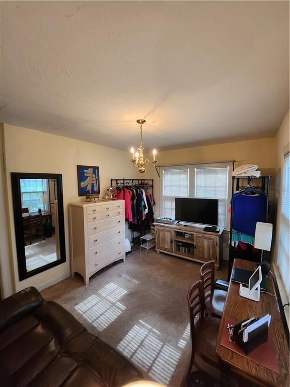 315 N 1st St, Independence, KS 67301 - living room with a chandelier, carpet floors, and plenty of natural light