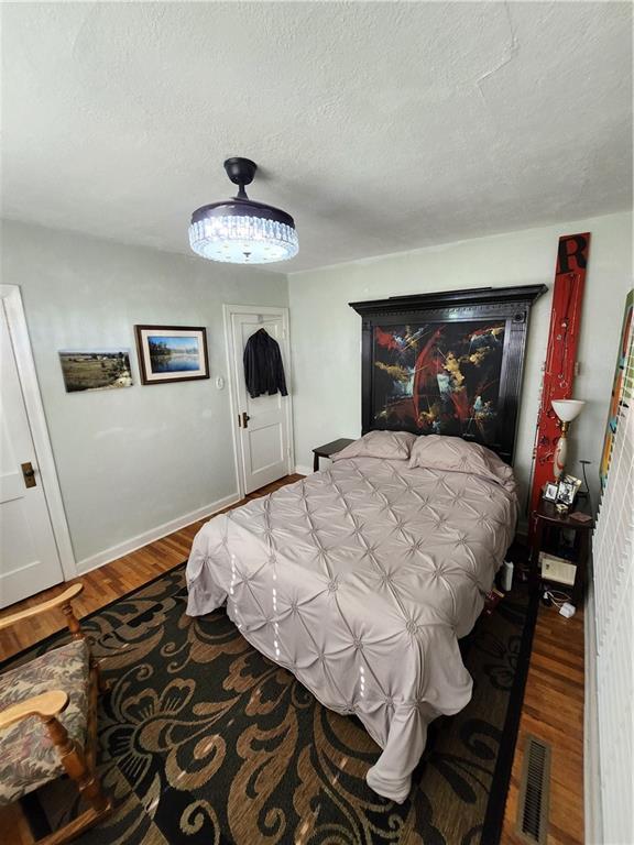 315 N 1st St, Independence, KS 67301 - bedroom featuring wood finished floors and a textured ceiling