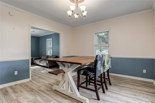 404 S Sycamore St, Ottawa, KS 66067 - dining space with a chandelier, plenty of natural light, light wood finished floors, and ornamental molding