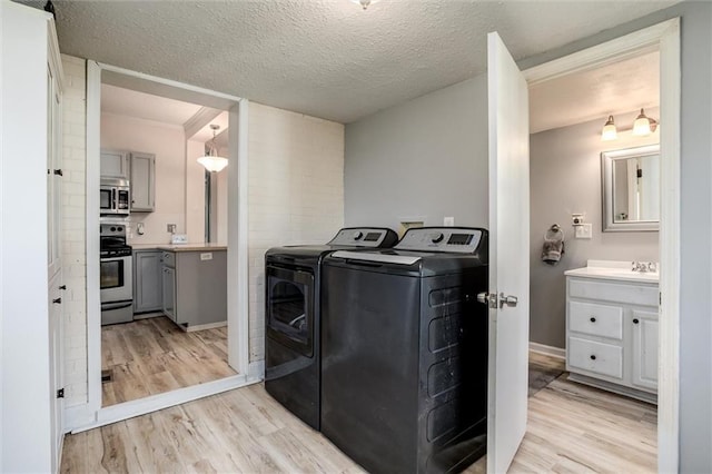 404 S Sycamore St, Ottawa, KS 66067 - washroom featuring independent washer and dryer, light wood finished floors, ornamental molding, and a textured ceiling