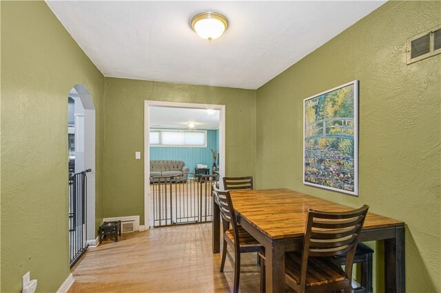 711 E 72nd Ter, Kansas City, MO 64131 - dining room with a textured wall, light wood-style flooring, and arched walkways