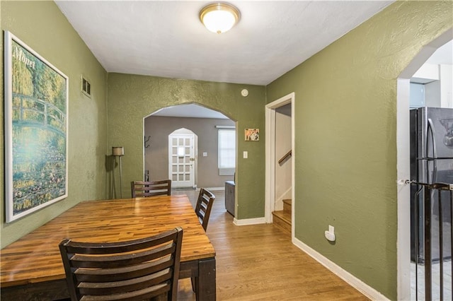 711 E 72nd Ter, Kansas City, MO 64131 - dining room with arched walkways, a textured wall, wood finished floors, and stairway