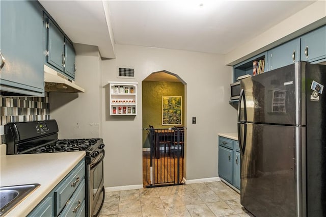 711 E 72nd Ter, Kansas City, MO 64131 - kitchen featuring freestanding refrigerator, range with gas cooktop, under cabinet range hood, arched walkways, and light countertops