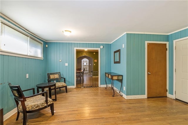 711 E 72nd Ter, Kansas City, MO 64131 - sitting room featuring ornamental molding, arched walkways, and light wood-style flooring