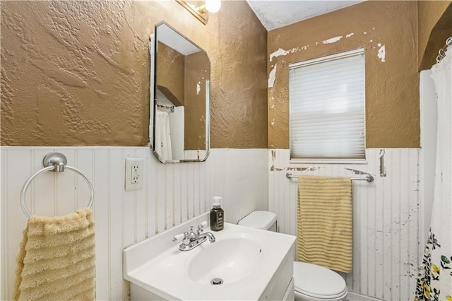 711 E 72nd Ter, Kansas City, MO 64131 - bathroom with a wainscoted wall, vanity, a textured wall, and a decorative wall