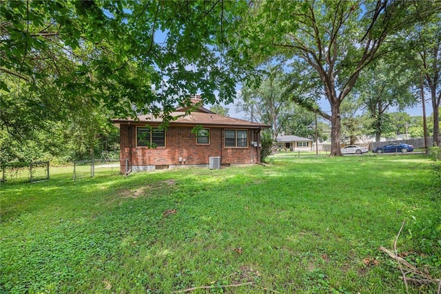 6327 Yecker Ave, Kansas City, KS 66104 - rear view of house featuring brick siding, a fenced backyard, and a chimney