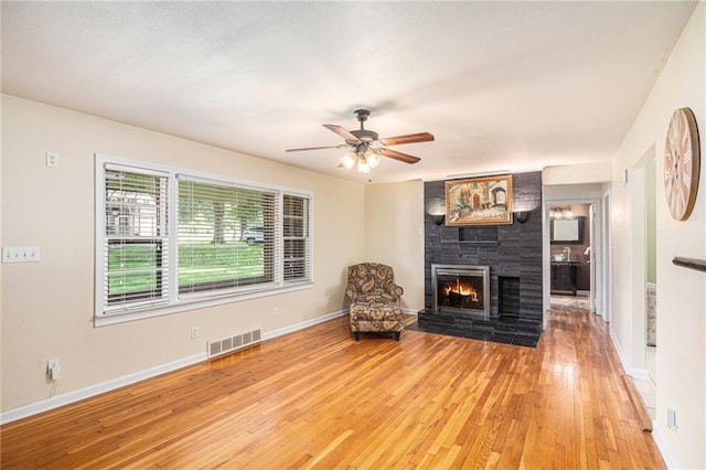 6327 Yecker Ave, Kansas City, KS 66104 - living room with light wood finished floors, a fireplace, and ceiling fan
