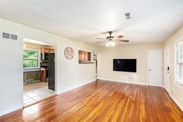 6327 Yecker Ave, Kansas City, KS 66104 - unfurnished living room featuring a ceiling fan and light wood-style flooring