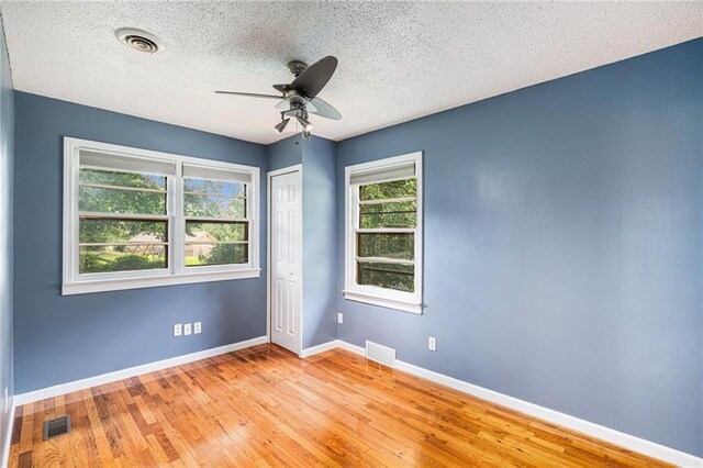 6327 Yecker Ave, Kansas City, KS 66104 - spare room with a textured ceiling, a ceiling fan, and wood finished floors