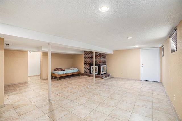 6327 Yecker Ave, Kansas City, KS 66104 - finished basement featuring a textured ceiling, a brick fireplace, and light tile patterned flooring