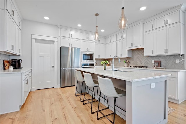 24704 W 76th St, Shawnee, KS 66227 - kitchen with freestanding refrigerator, built in microwave, tasteful backsplash, white cabinets, and light wood finished floors