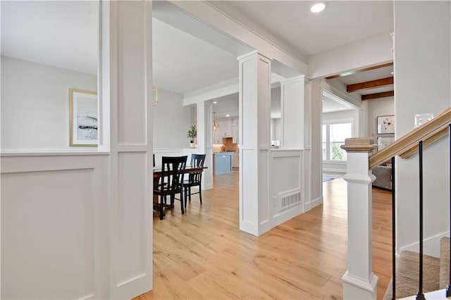 24704 W 76th St, Shawnee, KS 66227 - hallway featuring decorative columns, light wood finished floors, recessed lighting, a decorative wall, and stairs