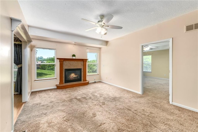 4204 Broadway Ter, Leavenworth, KS 66048 - unfurnished living room featuring a textured ceiling, a ceiling fan, carpet flooring, a glass covered fireplace, and healthy amount of natural light