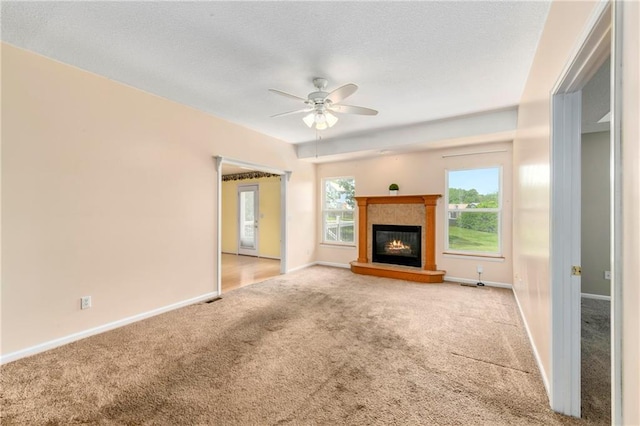 4204 Broadway Ter, Leavenworth, KS 66048 - unfurnished living room featuring carpet flooring, a ceiling fan, a glass covered fireplace, and a textured ceiling