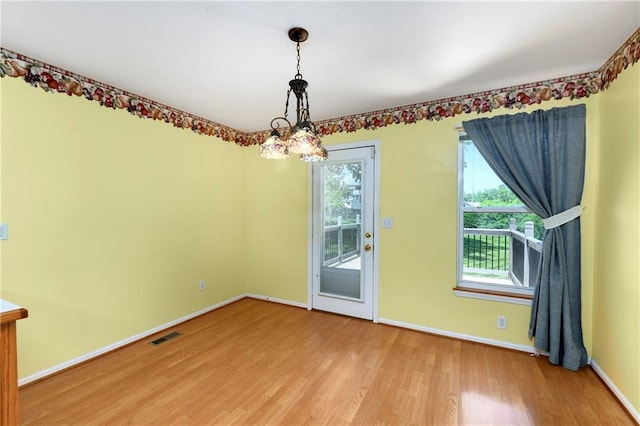 4204 Broadway Ter, Leavenworth, KS 66048 - unfurnished dining area with light wood-style floors, healthy amount of natural light, and a chandelier