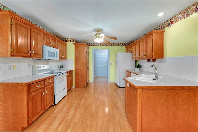 4204 Broadway Ter, Leavenworth, KS 66048 - kitchen with white appliances, ceiling fan, light wood-style flooring, light countertops, and backsplash