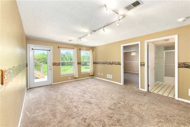 4204 Broadway Ter, Leavenworth, KS 66048 - unfurnished room featuring a textured ceiling, carpet flooring, rail lighting, plenty of natural light, and a smoke detector