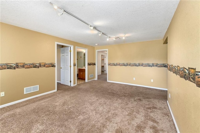 4204 Broadway Ter, Leavenworth, KS 66048 - carpeted empty room with a textured ceiling and rail lighting