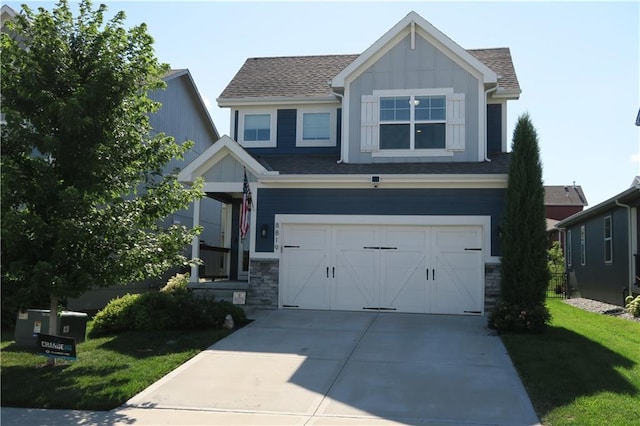 SW 8th St Unit 8819, Blue Springs, MO 64064 - view of front of property with board and batten siding, a garage, driveway, a front lawn, and roof with shingles