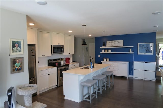 SW 8th St Unit 8819, Blue Springs, MO 64064 - kitchen with appliances with stainless steel finishes, dark wood-style floors, white cabinets, a breakfast bar area, and light countertops
