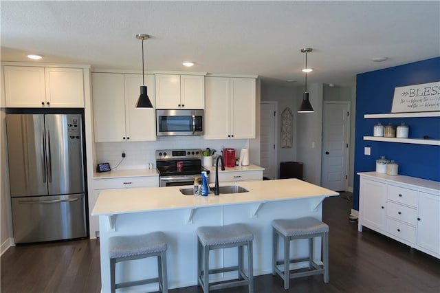 SW 8th St Unit 8819, Blue Springs, MO 64064 - kitchen featuring appliances with stainless steel finishes, white cabinetry, dark wood finished floors, a breakfast bar area, and recessed lighting