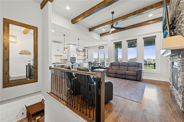 227 SW Eagles Ridge Dr, Blue Springs, MO 64014 - living room with ceiling fan, dark wood-style floors, beamed ceiling, a stone fireplace, and recessed lighting