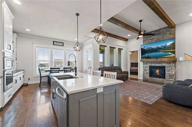 227 SW Eagles Ridge Dr, Blue Springs, MO 64014 - kitchen featuring a fireplace, appliances with stainless steel finishes, white cabinets, gray cabinetry, and dark wood-style flooring