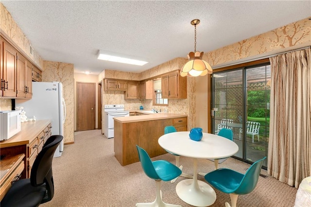 10432 Bond St, Overland Park, KS 66214 - kitchen featuring white appliances, a textured ceiling, a peninsula, plenty of natural light, and light countertops