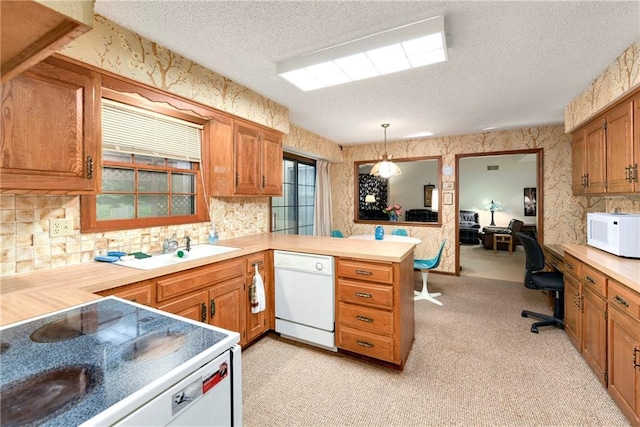 10432 Bond St, Overland Park, KS 66214 - kitchen featuring white appliances, a textured ceiling, wallpapered walls, a desk, and brown cabinets