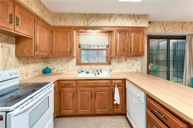 10432 Bond St, Overland Park, KS 66214 - kitchen featuring white appliances, brown cabinets, tasteful backsplash, a textured ceiling, and wallpapered walls