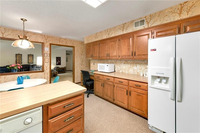 10432 Bond St, Overland Park, KS 66214 - kitchen with white appliances, wallpapered walls, brown cabinetry, a desk, and decorative light fixtures