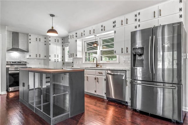 1480 E 76th Ter, Kansas City, MO 64131 - kitchen featuring stainless steel appliances, wall chimney exhaust hood, backsplash, and white cabinets