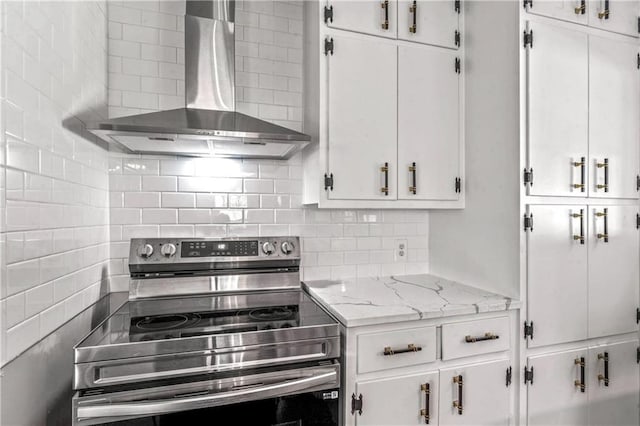1480 E 76th Ter, Kansas City, MO 64131 - kitchen featuring stainless steel electric range oven, wall chimney range hood, white cabinets, tasteful backsplash, and light stone countertops